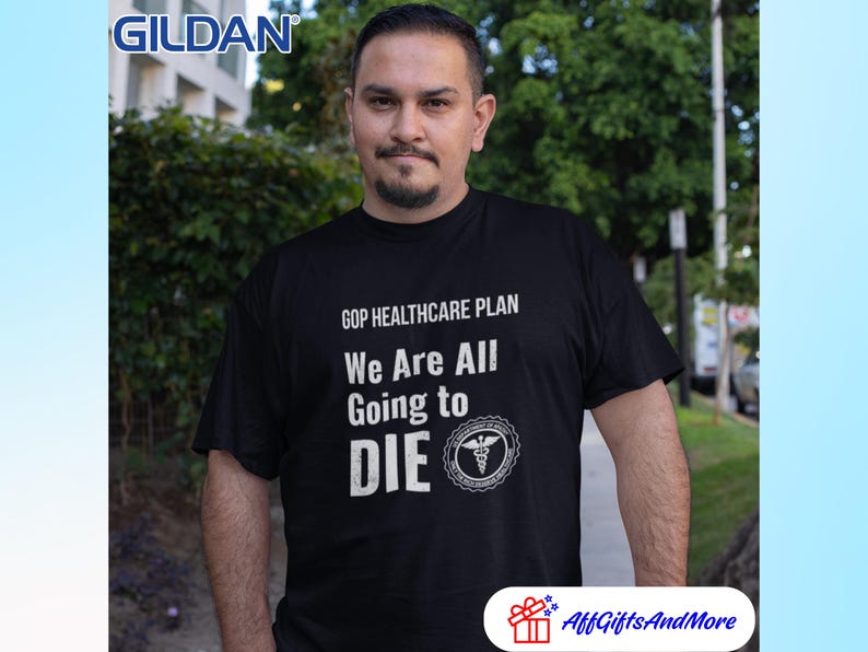 May include: Black t-shirt with the text "GOP HEALTHCARE PLAN We Are All Going to DIE" in white. The shirt features a medical symbol and is worn by a person. The Gildan logo is visible in the upper left corner.