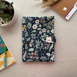 Groene handgemaakte boekenhoes met bloemenpatroon en meerdere vakken