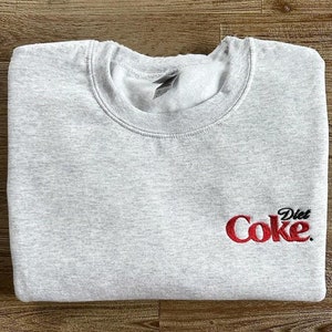 May include: Gray sweatshirt with a red embroidered logo that says "Diet Coke."