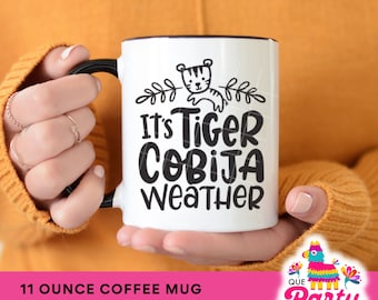 Spanglish Coffee Mug Reads: "It's Tiger Cobija Weather"