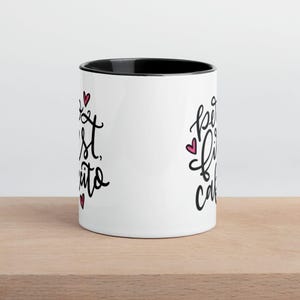 May include: White ceramic mug with a black rim. The mug has black text that says "Best Friends" on the left side and "Forever Cake" on the right side. There are small pink hearts scattered around the text.