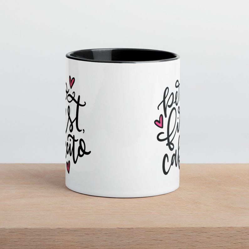 May include: White ceramic mug with a black rim. The mug has black text that says "Best Friends" on the left side and "Forever Cake" on the right side. There are small pink hearts scattered around the text.