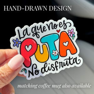 May include: A white sticker with colorful lettering that reads "La que no es PUTA no disfruta". The sticker has a hand-drawn style with flowers and hearts.