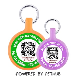 Könnte beinhalten: Zwei runde Haustier-ID-Tags mit QR-Codes und Kontaktinformationen. Das orangefarbene Schild sagt "scan with camera phone Hi I'm Millie. 123-45" und das lilafarbene Schild sagt "Please scan or call Penny 123-456-7890". Beide Schilder haben den Text "PetHub.me/A2B3C4" und das Logo "POWERED BY PETHUB".