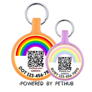 Puede incluir: Dos etiquetas de identificación para mascotas con diseños de arcoíris. Una es naranja con un arcoíris y el nombre "DOT" y un número de teléfono. La otra es lavanda con un arcoíris pastel y el nombre "RUBY" y un número de teléfono. Ambas tienen códigos QR.