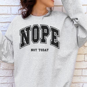 May include: A grey sweatshirt with a black graphic that says "NOPE NOT TODAY" in a vintage collegiate style font.