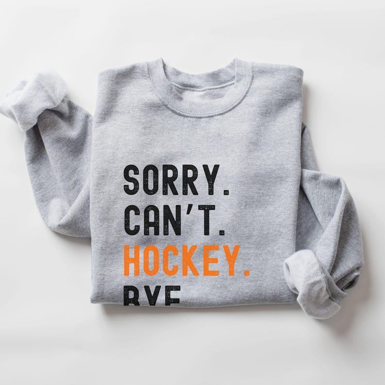 May include: Gray sweatshirt with the text "SORRY. CAN'T. HOCKEY." in black with the word "HOCKEY" in orange.