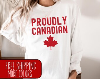 May include: White long-sleeve sweatshirt with the text "Proudly Canadian" in red lettering and a red maple leaf graphic.