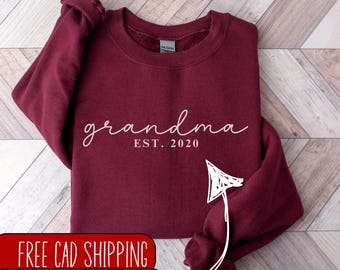 May include: Burgundy sweatshirt with the text "grandma est. 2020" in white.