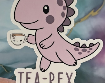 May include: A pink cartoon dinosaur holding a teacup with the text "TEA-REX" below. The dinosaur has a purple crest and spots.