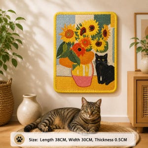 Puede incluir: Un tapiz rectangular de tufting que muestra un ramo de girasoles amarillos y naranjas en un jarr&oacute;n rosa junto a un gato negro. La pieza tiene un borde amarillo y mide 38 cm de largo, 30 cm de ancho y 0,5 cm de grosor.