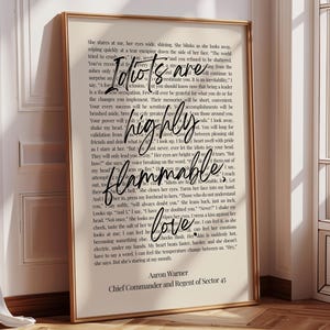 May include: A framed print with a gold border features a quote with the words "Idiots are highly flammable love" in a cursive font. The print has a beige background with black text.