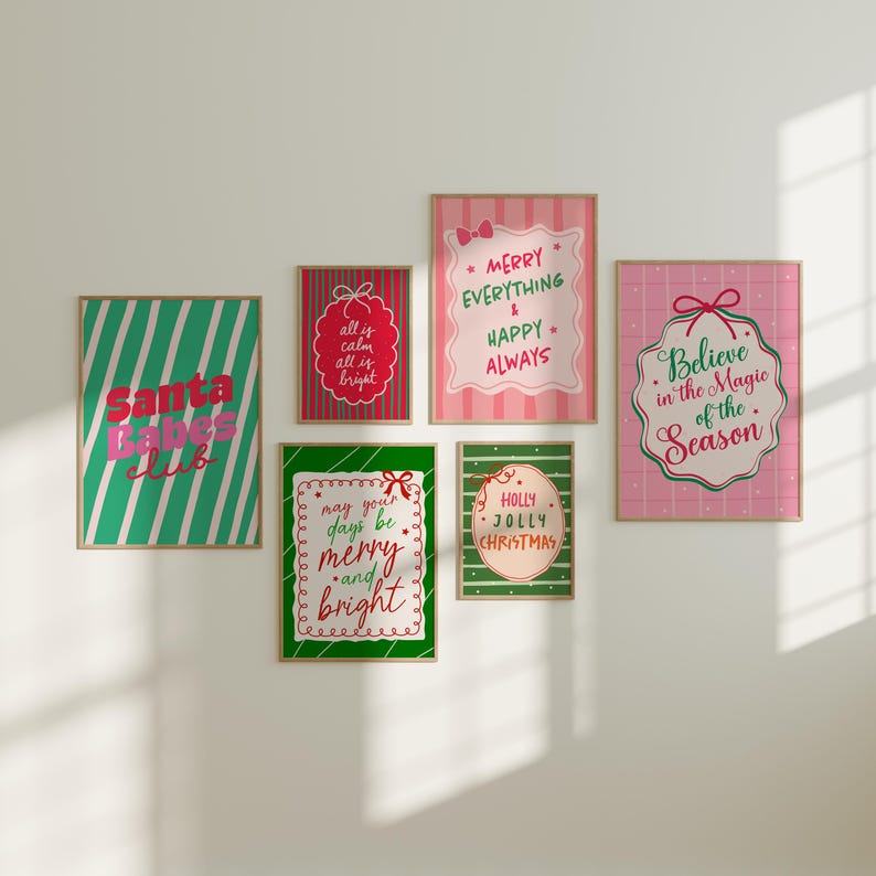 May include: A collection of framed Christmas-themed art prints. The prints feature festive phrases like "Santa Babes Club," "Merry Everything," and "Believe in the Magic of the Season." The color palette includes green, red, and pink with white text.