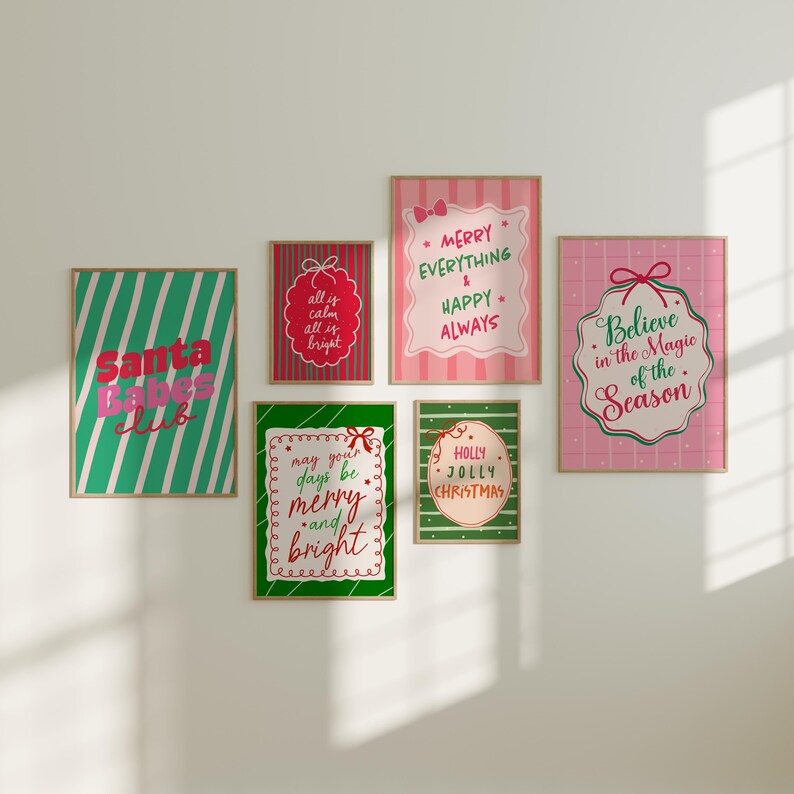 May include: A collection of framed Christmas-themed art prints. The prints feature festive text and designs in red, green, and pink. The phrases include "Santa Babes Club," "Merry Everything & Happy Always," and "Believe in the Magic of the Season."
