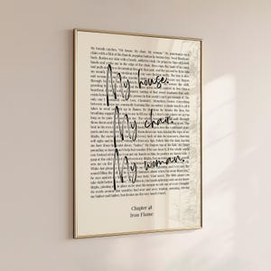 Puede incluir: Una impresi&oacute;n enmarcada con borde dorado presenta una p&aacute;gina de libro con las palabras "My house. My chair. My woman." en una fuente manuscrita. El texto "Chapter 48 Iron Flame" est&aacute; en la parte inferior.