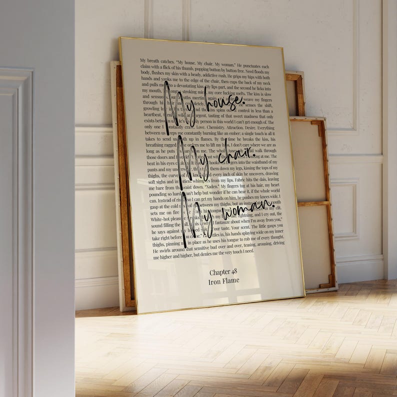 Puede incluir: Una impresi&oacute;n enmarcada con texto del Cap&iacute;tulo 48, "Iron Flame". Las palabras "My house, My chair, My woman" est&aacute;n escritas en cursiva en la p&aacute;gina. El marco es dorado.
