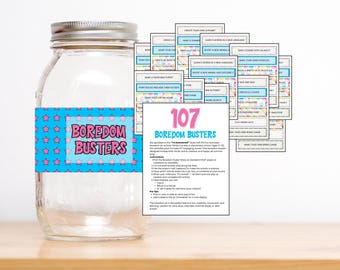 May include: A glass jar with a silver lid and a blue label reading "Boredom Busters". The jar is filled with activity cards, offering fun ideas for children. The jar is approximately 15 cm tall.