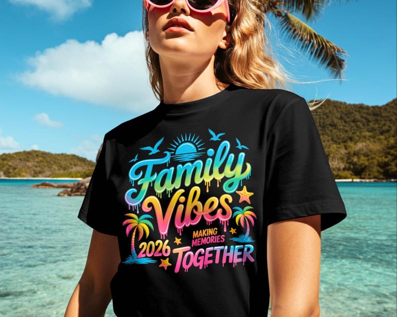 May include: Black t-shirt with a colorful graphic that reads "Family Vibes Making Memories Together 2026." The design includes a sun, birds, palm trees, and stars in shades of blue, yellow, pink, and green.