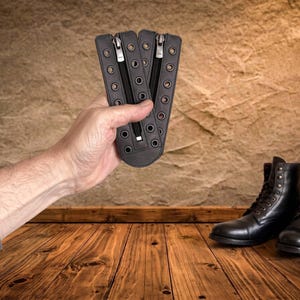 May include: Two black leather boot lace-in zipper inserts featuring silver-toned metal zippers and two vertical rows of reinforced metal eyelets for lacing, designed to be inserted into the front of a pair of black leather lace-up boots.