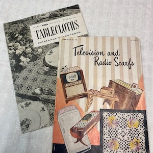 May include: Two vintage craft books with striped covers. The top book is titled "Tablecloths Heirlooms of Tomorrow" and the bottom book is titled "Television and Radio Scarfs".