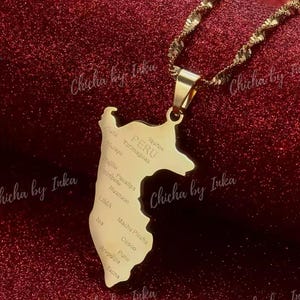 Puede incluir: Un collar de oro con un colgante con forma del contorno de Perú. El colgante tiene los nombres de las ciudades y regiones de Perú grabados en él.
