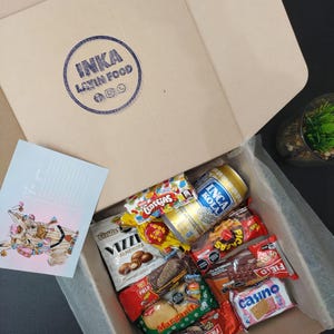 Peruvian candies surprise box with a handmade loom and keychain. Includes a postcard with a lama drawing designed by artist M. Pérez