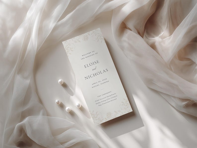 Może przedstawiać: Prostokątna karta z programem ślubnym w kolorze kremowym z ciemnoszarym tekstem szeryfowym o treści Welcome to the wedding of Eloise and Nicholas, April 27, 2024, Naples, Florida oraz The Ceremony. Karta zawiera delikatne kwiatowe wzory i cztery perły.