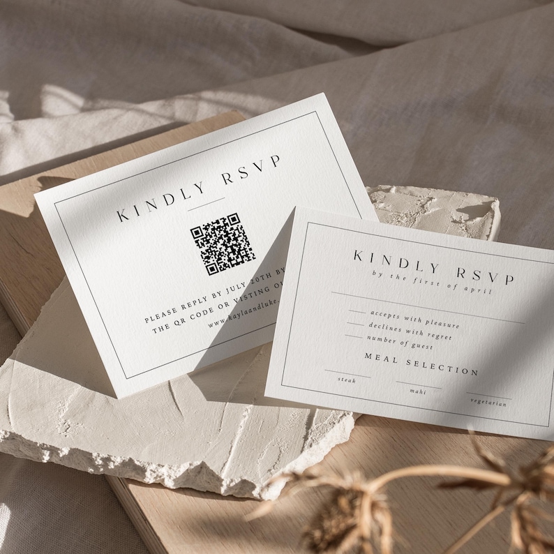 Pu&ograve; includere: Due biglietti RSVP bianchi con testo nero. Un biglietto recita "KINDLY RSVP" e include un codice QR e le istruzioni per la risposta. L'altro biglietto presenta i dettagli RSVP e le opzioni di selezione dei pasti. I biglietti sono su una superficie neutra.