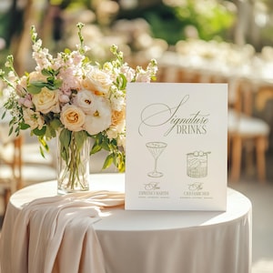 Puede incluir: Una mesa decorada con un arreglo floral y un letrero que dice "Signature Drinks". El letrero presenta ilustraciones de c&oacute;cteles, incluyendo un Espresso Martini y un Old Fashioned. La mesa est&aacute; cubierta con un mantel blanco.