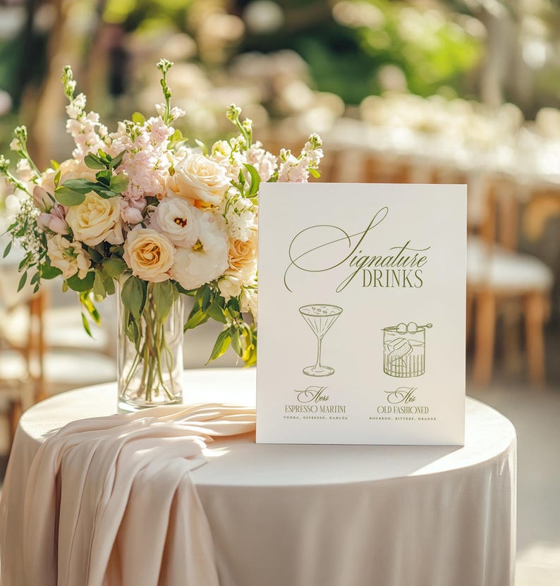 Puede incluir: Una mesa decorada con un arreglo floral y un letrero que dice "Signature Drinks". El letrero presenta ilustraciones de c&oacute;cteles, incluyendo un Espresso Martini y un Old Fashioned. La mesa est&aacute; cubierta con un mantel blanco.