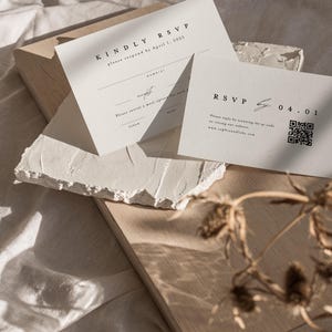 May include: A white RSVP card with black text. The text reads "Kindly RSVP, please respond by April 1, 2025". There is a smaller white card with black text that reads "RSVP by 04.01".