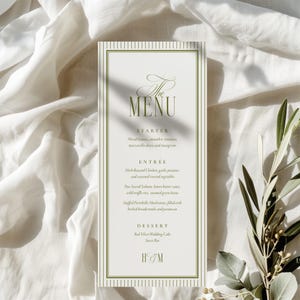 Könnte beinhalten: Eine Hochzeitsmenükarte mit weißem Hintergrund und grünem Text. Das Menü umfasst Vorspeisen, Hauptgerichte und Desserts. Die Karte hat einen grün gestreiften Rand und die Initialen "H & M" unten.