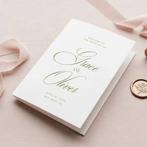 Puede incluir: Un programa de boda blanco con letras verdes que dice "Bienvenida a la boda de Grace y Oliver" y la fecha 28 de junio de 2028, en Key West, FL. Un sello de cera dorado y una cinta rosa est&aacute;n en el fondo.