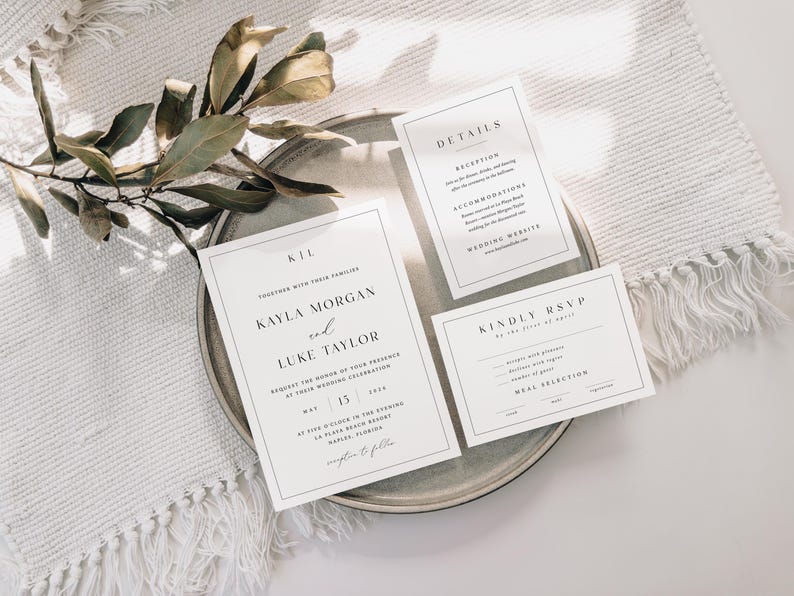 Pu&ograve; includere: Elegante set di partecipazioni di nozze dal design minimalista. Il set include un invito, una scheda dettagli e una scheda RSVP, tutti con testo nero su sfondo bianco. Le carte sono disposte su un piatto grigio, con un rametto di verde.