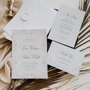 May include: A wedding invitation suite featuring a main card, a details card, and an RSVP card with elegant serif typography and floral border illustrations. The set includes white envelopes, one sealed with a wax stamp, and a gold metal wax seal tool.