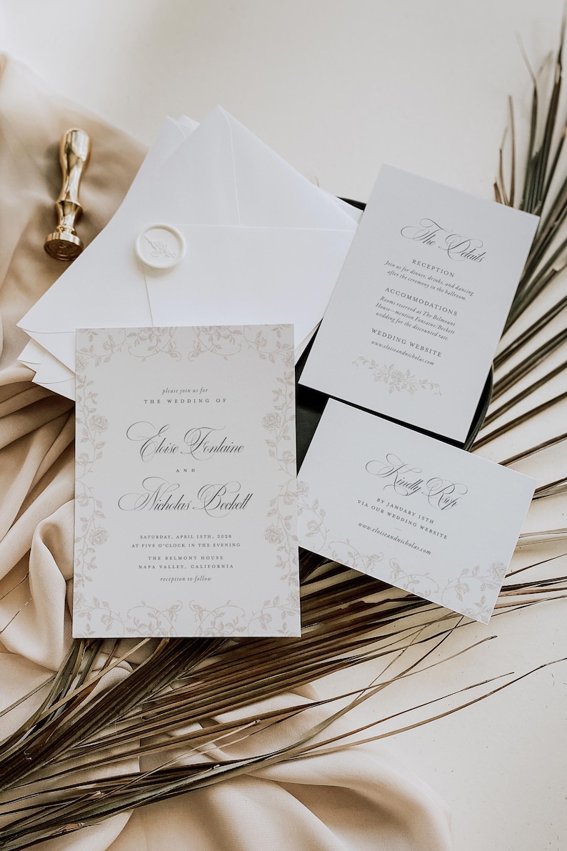May include: A wedding invitation suite featuring a main card, a details card, and an RSVP card with elegant serif typography and floral border illustrations. The set includes white envelopes, one sealed with a wax stamp, and a gold metal wax seal tool.