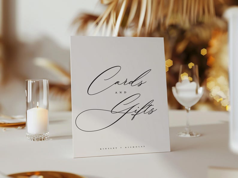 May include: White card with black calligraphy that reads "Cards and Gifts" with the names "Kimberly & Nicholas" at the bottom.