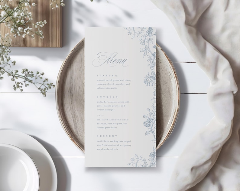 May include: A vertical rectangular menu card with a light gray background and blue floral illustrations along the right edge. The text includes the word Menu followed by sections for Starter, Entree, and Dessert with detailed food descriptions.