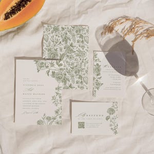 May include: A wedding stationery set featuring cream-coloured paper with sage green botanical illustrations. The set includes a main invitation, a smaller details card, an RSVP card with a QR code, and a square envelope liner with a floral pattern.