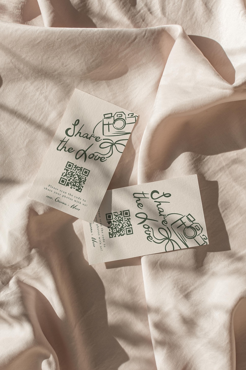 May include: Two white cards with a green camera icon and the text "Share the Love" printed on them. Each card has a QR code and instructions to scan the code to share photos.