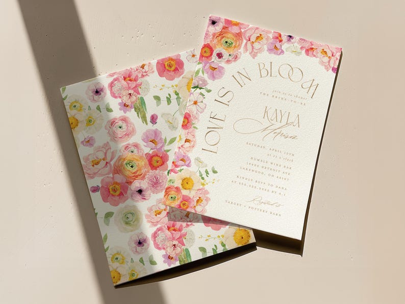 May include: Two floral wedding invitations with a watercolour design. The invitations feature pink, yellow, and peach flowers with green leaves. One invitation reads "Love is in Bloom" and includes event details.