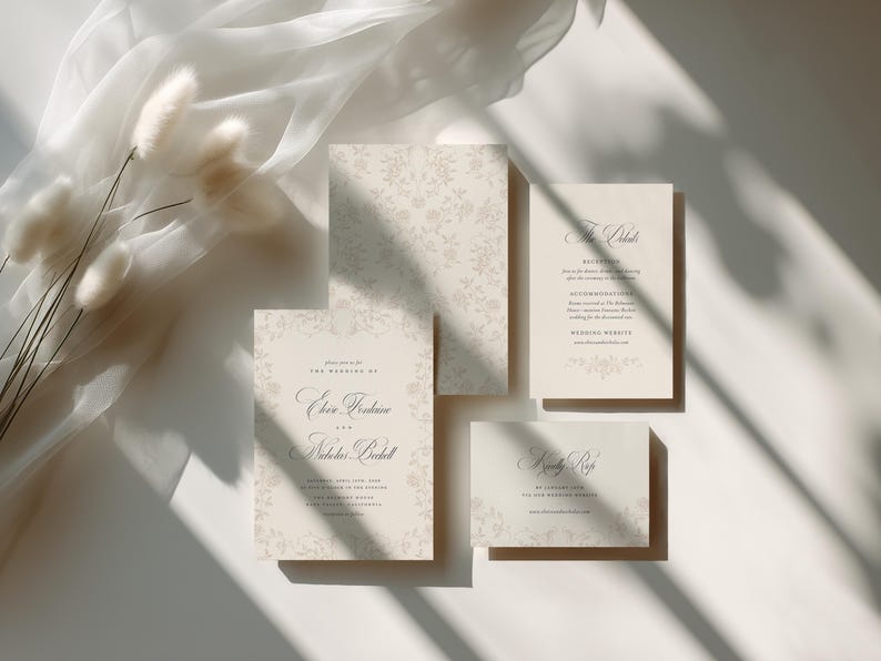 May include: A set of cream-colored wedding stationery featuring delicate floral patterns and elegant serif typography. The collection includes a main invitation, a reception card, and an RSVP card, all printed on high-quality cardstock paper.