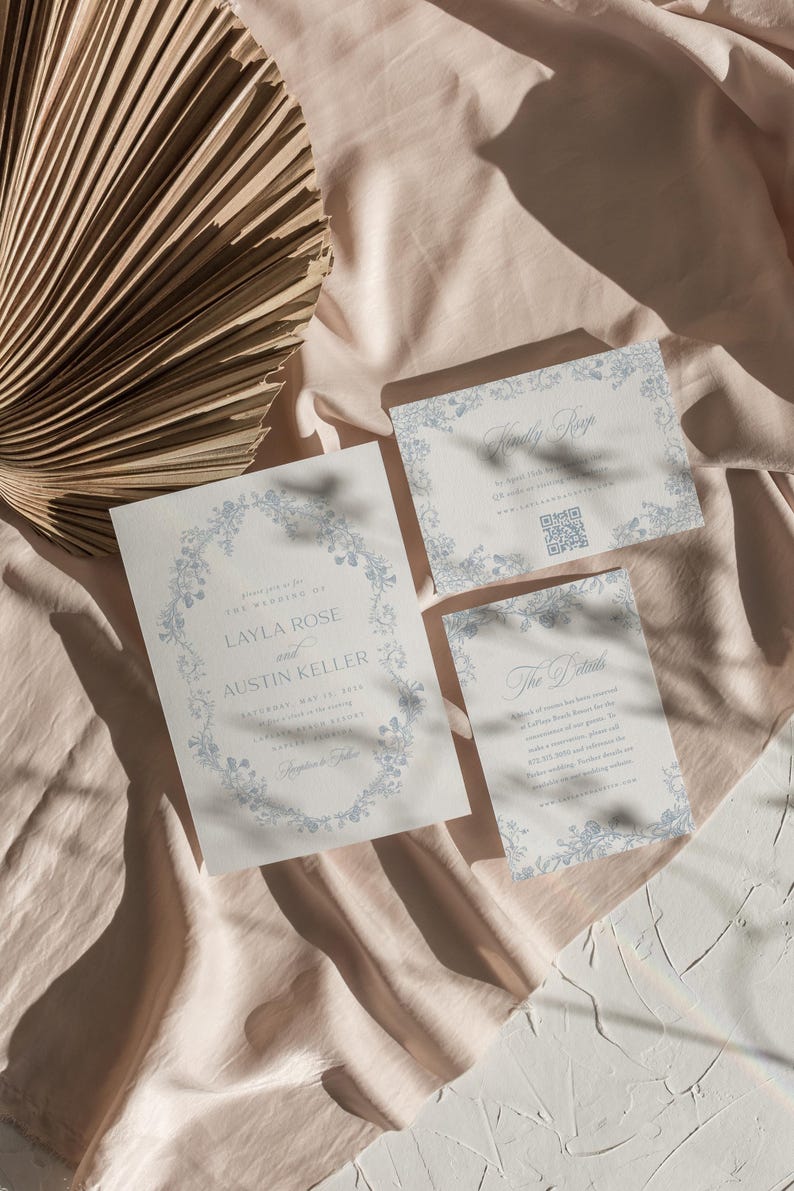 May include: Wedding invitation suite with a floral design in blue and white. The invitation card features the text "Please join us for the wedding of Layla Rose and Austin Keller". The RSVP card has the text "Kindly RSVP" and a QR code. The details card has the text "The Details".