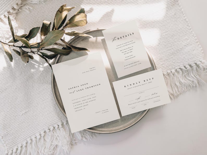 May include: A set of three white wedding invitation cards with black text. The main card reads "Sophia Soo & Luke Thompson". The second card reads "Details" and the third card reads "Kindly RSVP".