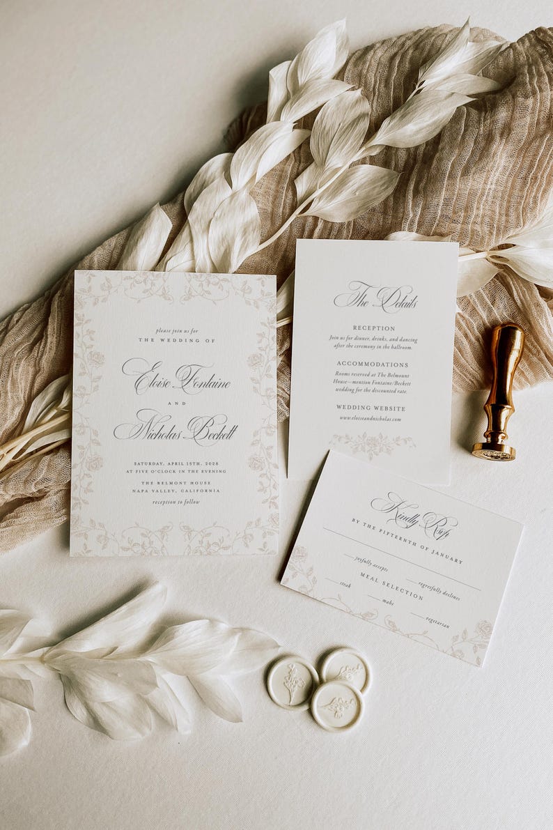 May include: A wedding invitation suite featuring a main invitation, a details card, and an RSVP card with floral borders and elegant typography. Includes a gold wax seal stamp and three small white wax seals with embossed floral designs.