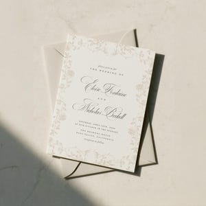 May include: A rectangular wedding invitation card with a cream background and a delicate beige floral border. The text reads: Please join us for THE WEDDING OF Eloise Fontaine AND Nicholas Bechell SATURDAY, APRIL 13TH, 2024 AT FIVE O'CLOCK IN THE EVENING THE BELMONT HOUSE NAPA VALLEY, CALIFORNIA reception to follow.