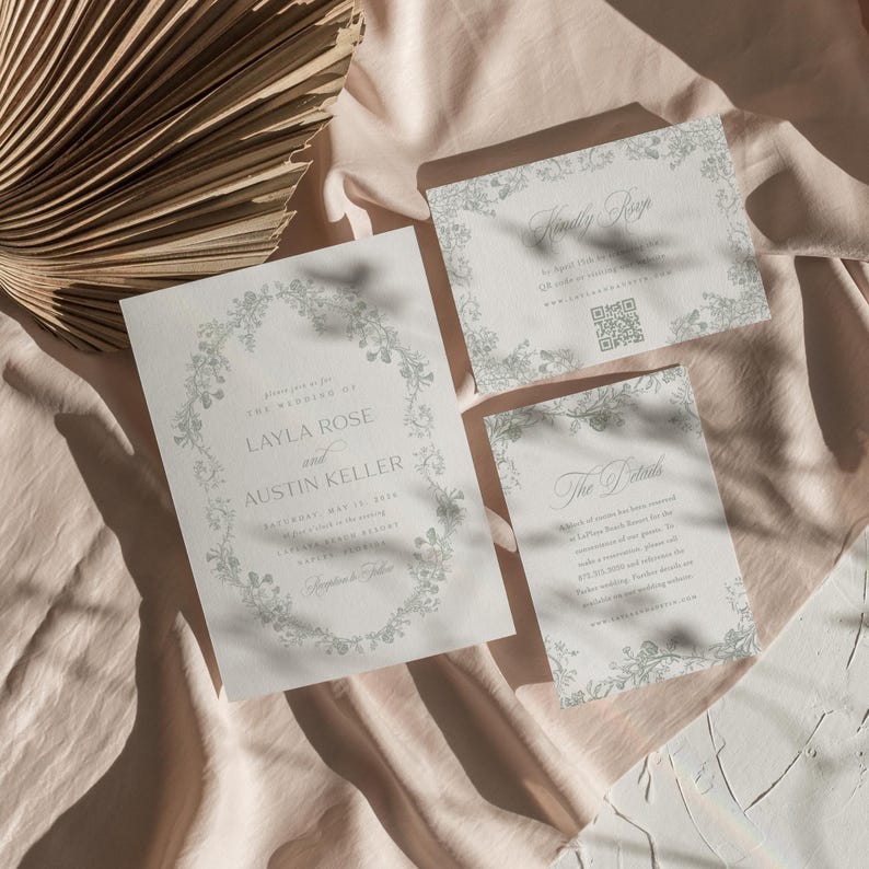 Op de afbeelding: Een huwelijksuitnodigingsset met een bloemenontwerp. De hoofduitnodigingskaart heeft een krans van delicate bloemen en de tekst "U wordt uitgenodigd voor de bruiloft van Layla Rose en Austin Keller". De RSVP-kaart heeft de tekst "Graag uw antwoord" en een QR-code. De detailkaart heeft de tekst "De details" en informatie over de bruiloft.