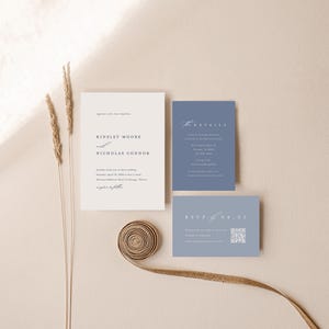 Op de afbeelding: Een huwelijksuitnodigingsset met een witte kaart met de tekst "Kinsley Moore en Nicholas Connor" en een blauwe kaart met de tekst "Details" en "RSVP".