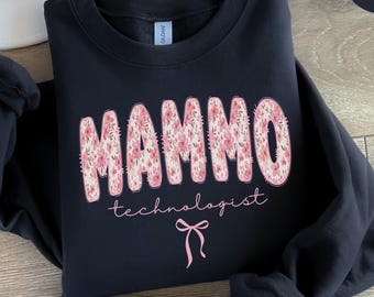 May include: Black sweatshirt with the word "MAMMO" in large, floral-patterned letters, and "technologist" in a script font. A pink bow graphic is below the text. The word "BLACK" is in a black oval in the upper right corner.