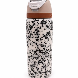 Pu&ograve; includere: Una borraccia riutilizzabile con un motivo maculato bianco e nero. Il coperchio &egrave; beige e grigio con una fascia marrone. Sul coperchio c'&egrave; la scritta "Lift to Unlock".